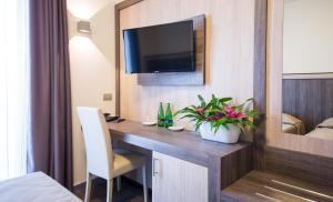 a hotel room with a desk with a tv on a wall at Hotel Colombera Rossa in Brescia