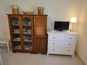 Zimmer mit einem Schrank, einem TV und einer Kommode in der Unterkunft Belvilla by OYO Venturi Lemon in Gatteo a Mare