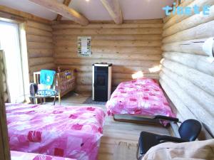a bedroom with a bed in a log cabin at Tigete Holiday Cottage in Lootvina