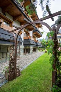 a building with an archway in front of a yard at Hotel Skalny in Zakopane