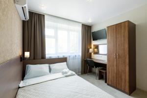 ケメロヴォにあるАвионのベッドとデスクが備わるホテルルームです。