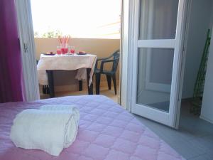 a bedroom with a pink bed and a table with a table at Residence Le Isole in Marsala