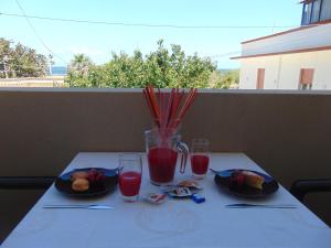 a table with two plates of food and drinks on it at Residence Le Isole in Marsala