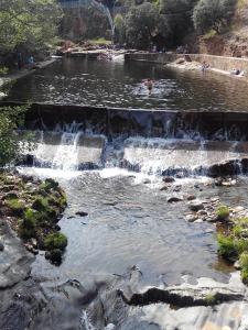 un étang avec une cascade dans un parc dans l'établissement Sabores Hurdanos, à Las Mestas