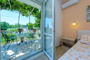 a bedroom with a bed and a balcony with a table at Villa Ive in Mlini