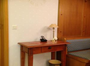 een bureau met een telefoon en een lamp erop bij Landhaus Vogelweide - 2 Zimmer mit Balkon in Bad Füssing