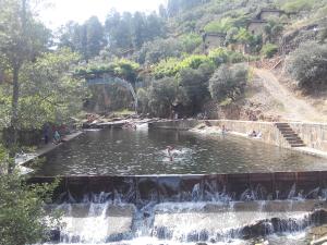 a person swimming in a pond in a waterfall at Sabores Hurdanos in Las Mestas