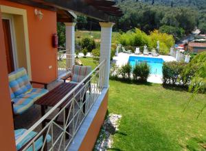 balcón de una casa con vistas a la piscina en Villa Grecia, en Liapades