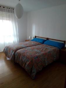 una camera da letto con un letto con lenzuola blu e una finestra di Casa Josefina a Armunia