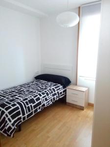 a bedroom with a black and white bed and a wooden floor at Casa Josefina in Armunia +8 photos