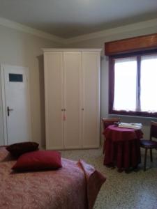 a bedroom with a bed and a table and a window at Hotel Signorini in Castiglioncello