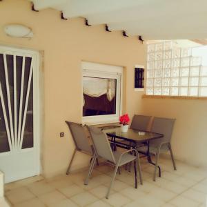 a dining room with a table and chairs and a window at The Garden Apartments in Nea Kallikrateia