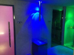 a bathroom with blue and green lights and a mirror at Splendido Bay Luxury Spa Resort in Padenghe sul Garda