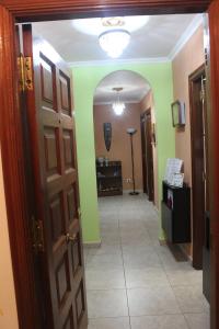 a hallway with green walls and an open door at Tximeleta Bidean in Arzúa