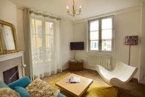 a living room with a blue couch and a chair at Les Apparts du Plot in Le Puy-en-Velay