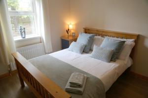 een slaapkamer met een groot bed met witte lakens en kussens bij Millstone Park Apartment in Portstewart