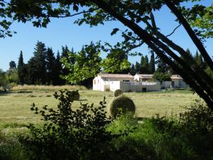 a house in a field with hay bales at Maison de la Mascotte in Châteaurenard