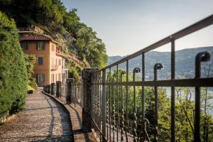 een hek op een heuvel met uitzicht op het water bij La Dolce Vita - The House Of Travelers in Como