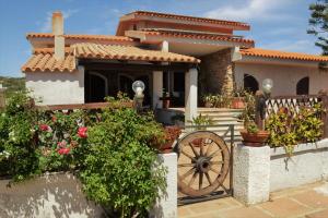 a house with a wooden wheel in front of it at Villa Gandamar in Santa Teresa Gallura