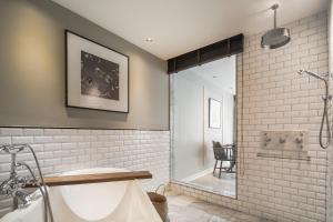 a bathroom with a shower and a bath tub at Hotel Once Bangkok in Bangkok