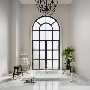 a bath tub in a room with a large window at Hotel Once Bangkok in Bangkok