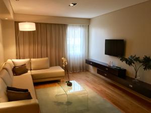 a living room with a couch and a flat screen tv at Hotel Metropolitano Supara in Buenos Aires