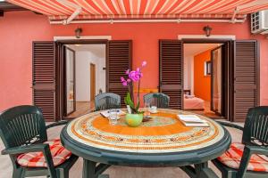a table with a vase of flowers on it at Apartments Roko in Rovinj +32 photos