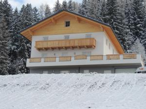 a building with a balcony on top of a snow covered slope at Appartments Rindisplatzl in Schladming