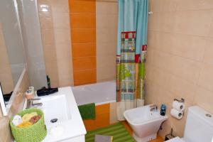 a bathroom with a sink and a toilet and a tub at Apartamento Funchal Sunshine in Funchal