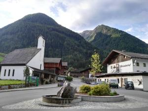 a town with a statue in front of a mountain at Lesacherhof in Kals am Großglockner