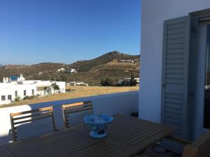 Gaia Serifos Apartments في Rámos: طاولة على شرفة مطلة على الجبال