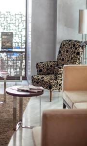a living room with a chair and a table at Soho Boutique Casa Don Fernando in Cáceres