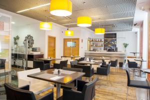 a restaurant with tables and chairs and yellow lights at Soho Boutique Casa Don Fernando in Cáceres