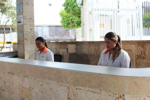 dos chicas con camisas blancas sentadas en un mostrador en Bosque Hotel, en Melgar
