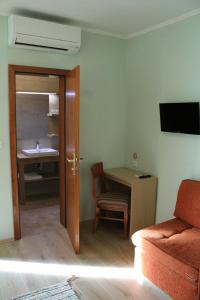 ein Wohnzimmer mit einem Sofa, einem Tisch und einem Waschbecken in der Unterkunft Penzion Gostisce Lesjak in Orehova vas 