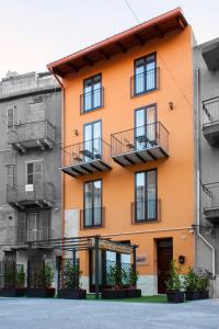 un edificio naranja con balcones en una calle en B&B La Piazzetta, en Licata