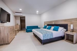 a bedroom with a bed and a flat screen tv at Hotel Rosales Boutique in Neiva
