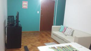 sala de estar con sofá blanco y TV en Departamento Vicente Lopez sobre Av Maipu en Vicente López