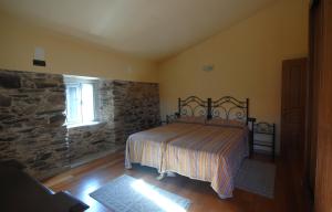 バルドビーニョにあるCasa Rural Pantinの石壁のベッドルーム1室(ベッド1台付)