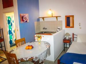 a kitchen with a table with a bowl of fruit on it at Aggelos Studios in Panormos Kalymnos