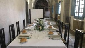 una mesa larga con copas de vino y flores. en San Nicolas el Real, en Villafranca del Bierzo