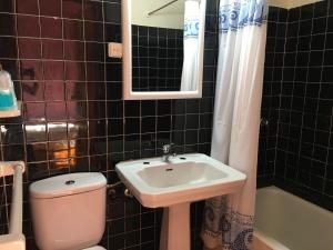 a bathroom with a sink and a toilet and a mirror at San Nicolas el Real in Villafranca del Bierzo