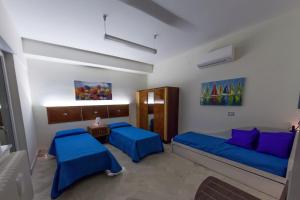 una camera con 2 letti e cuscini blu di La Quintessenza a Matera