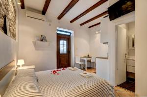 a bedroom with a bed with red roses on it at Apartman Amfiteatar Franko in Pula