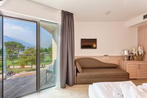 a bedroom with a bed and a sliding glass door at Hotel Bellariva in Riva del Garda