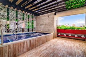 Hotel Rosales Boutique في نيفا: حوض استحمام ساخن في غرفة مع نافذة كبيرة