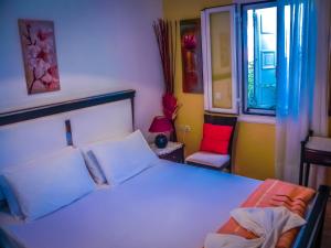 a bedroom with a white bed and a red chair at Aggelos Studios in Panormos Kalymnos