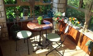 a patio with a table and chairs and a window at Guesthouse Leasol in Lucija