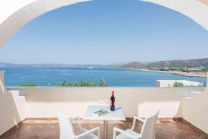 a white table with a bottle of wine on a balcony at Balos Beach in Kissamos