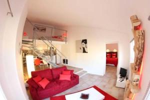 a living room with a red couch and a staircase at Gite Europa in Le Mas